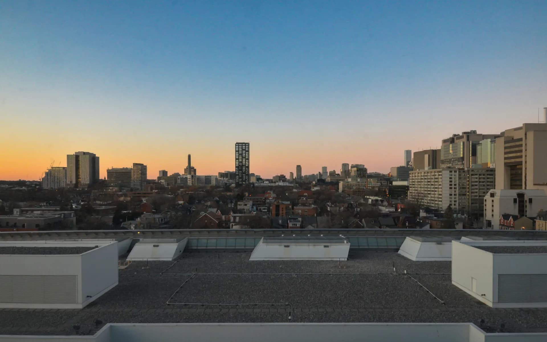 City skyline view from rooftop during sunset with modern buildings and golden hour lighting