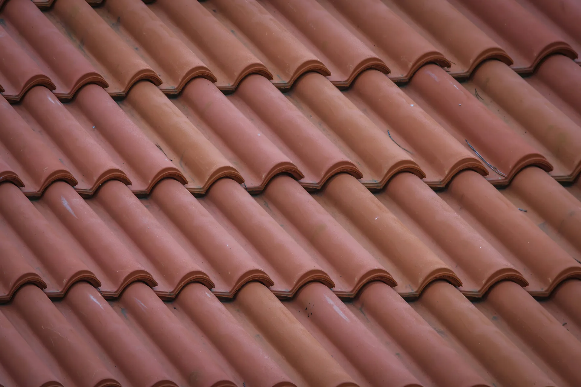 Red clay roof tiles arranged in overlapping curved rows showing Mediterranean-style roofing pattern